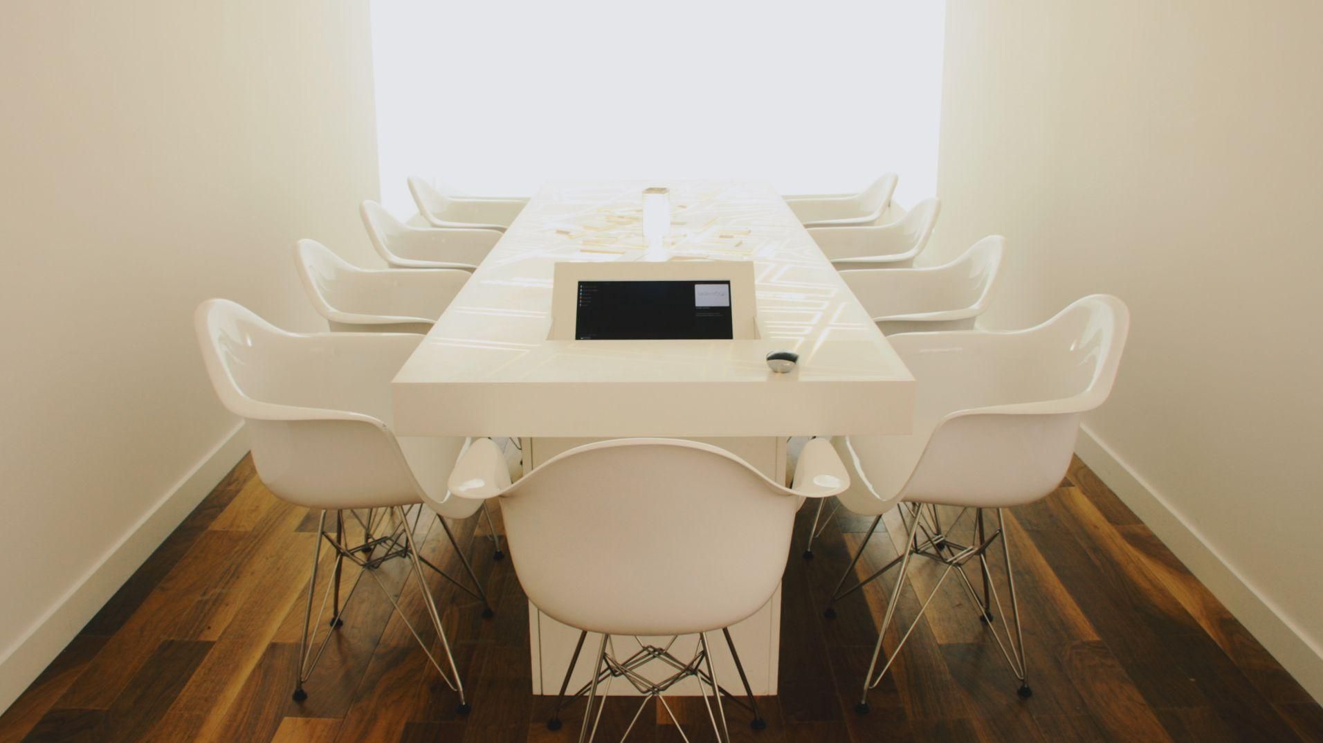 The white Dashwood meeting table and its central touchscreen in a bright presentation room.