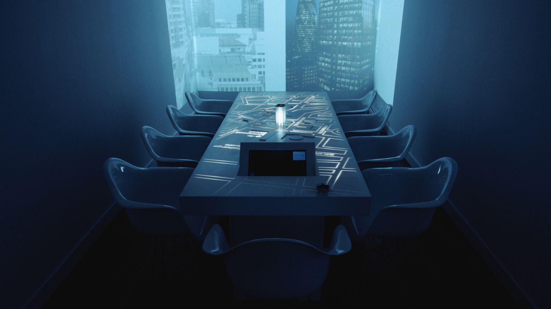 The Dashwood table in a darkened room with a cityscape projected across the wall.