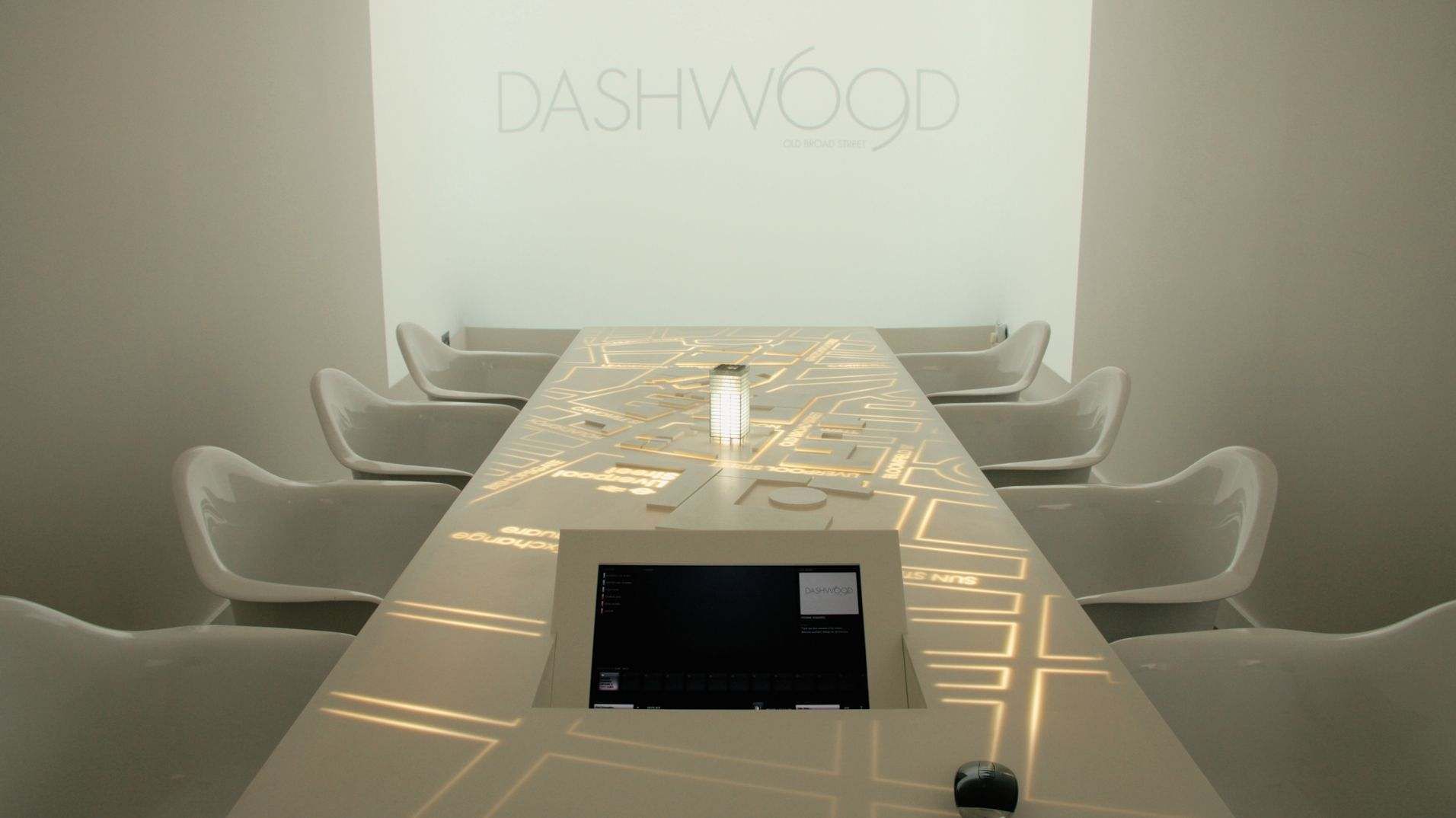 The table illuminated with a street map beneath a projected Dashwood presentation.