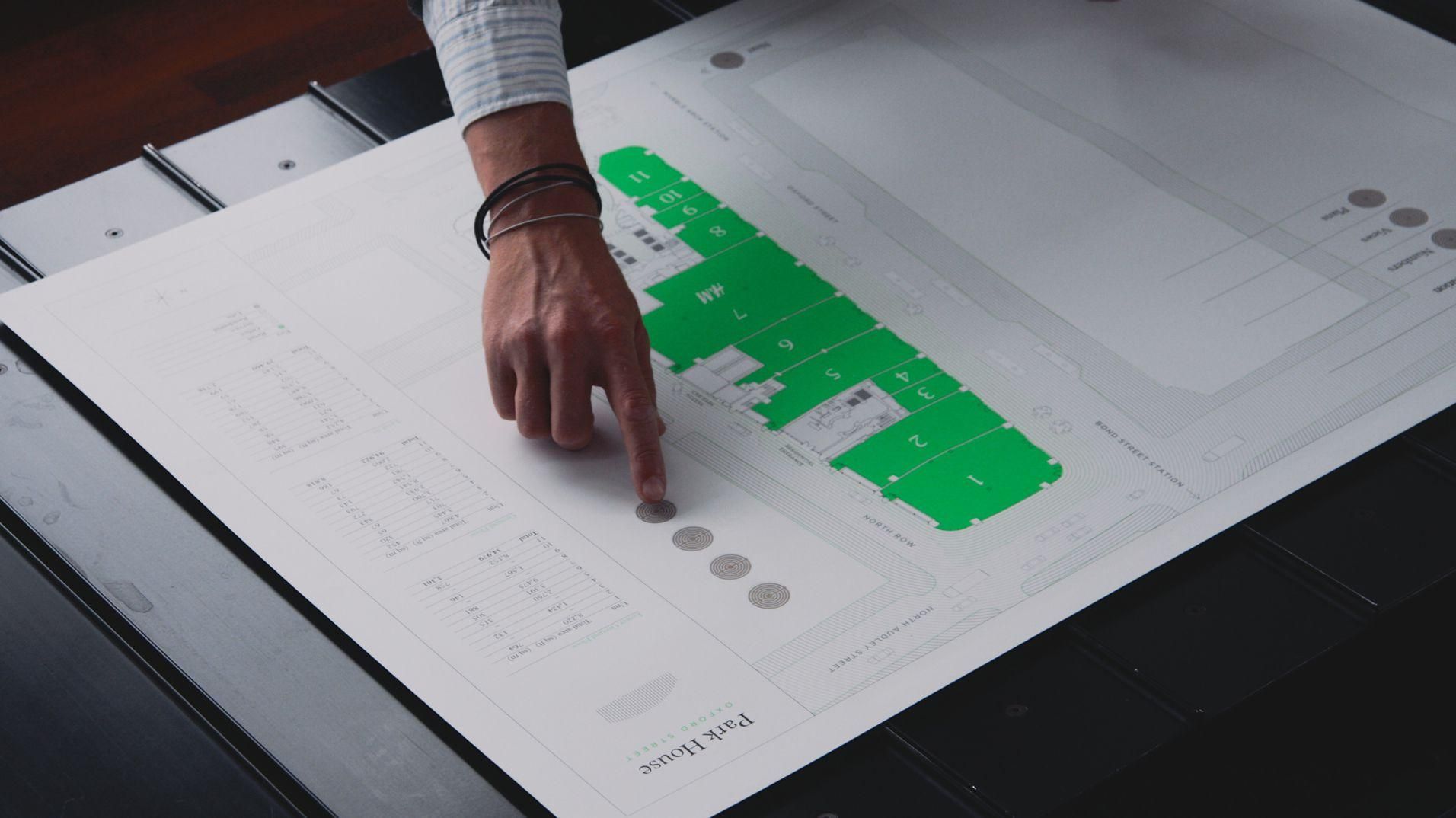 A sales agent selecting part of the Park House floor plan by touch.