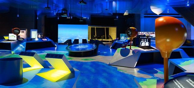 The full Atmosphere installation with angular displays, an orange globe and a central projection.