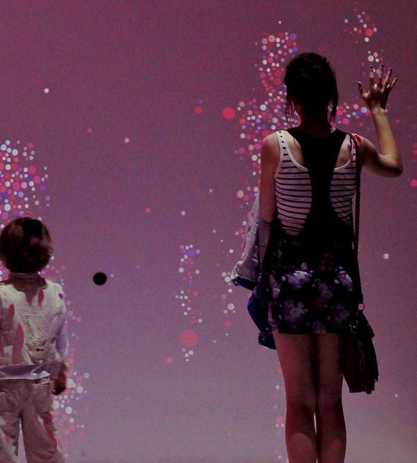 Visitors exploring tabletop interactive exhibits in the Science Museum Who Am I gallery.