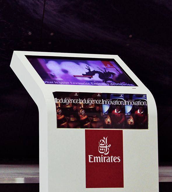 A visitor using an Emirates Hello Tomorrow touchscreen kiosk.