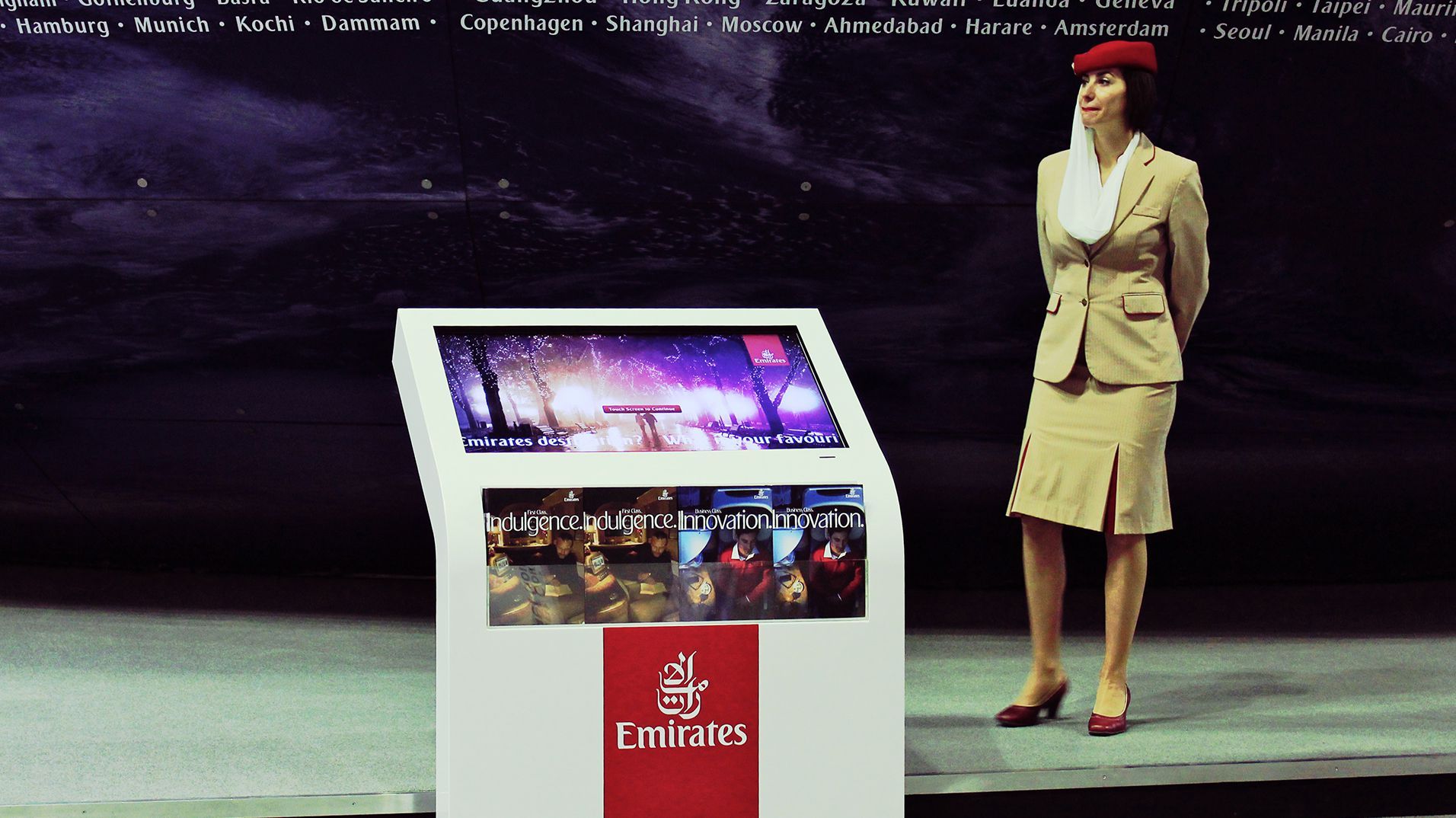 An Emirates Hello Tomorrow touchscreen kiosk presenting destinations at the Dubai trade show.