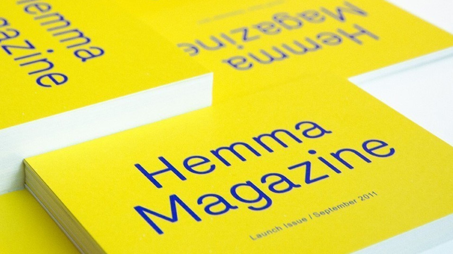 A stack of bright yellow Hemma Magazine launch publications.