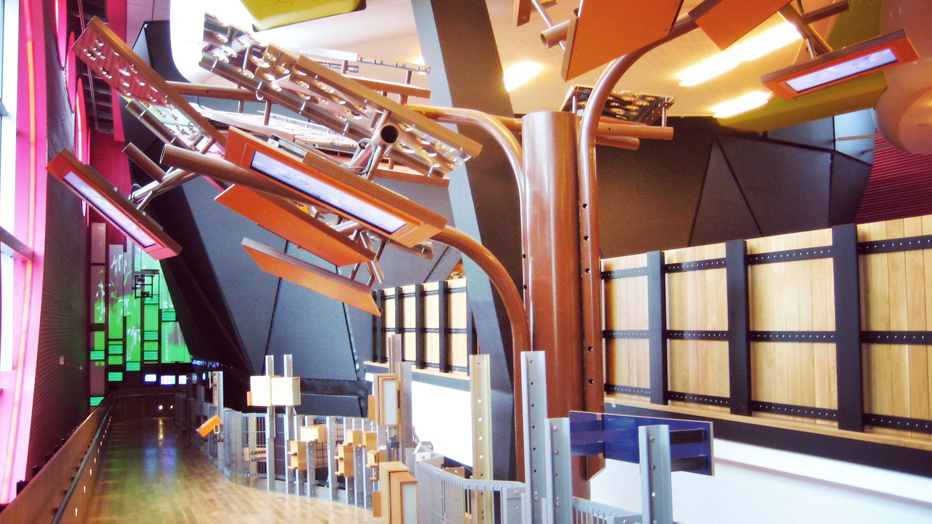 The Public's brightly coloured interior with suspended orange structures and interactive stations.