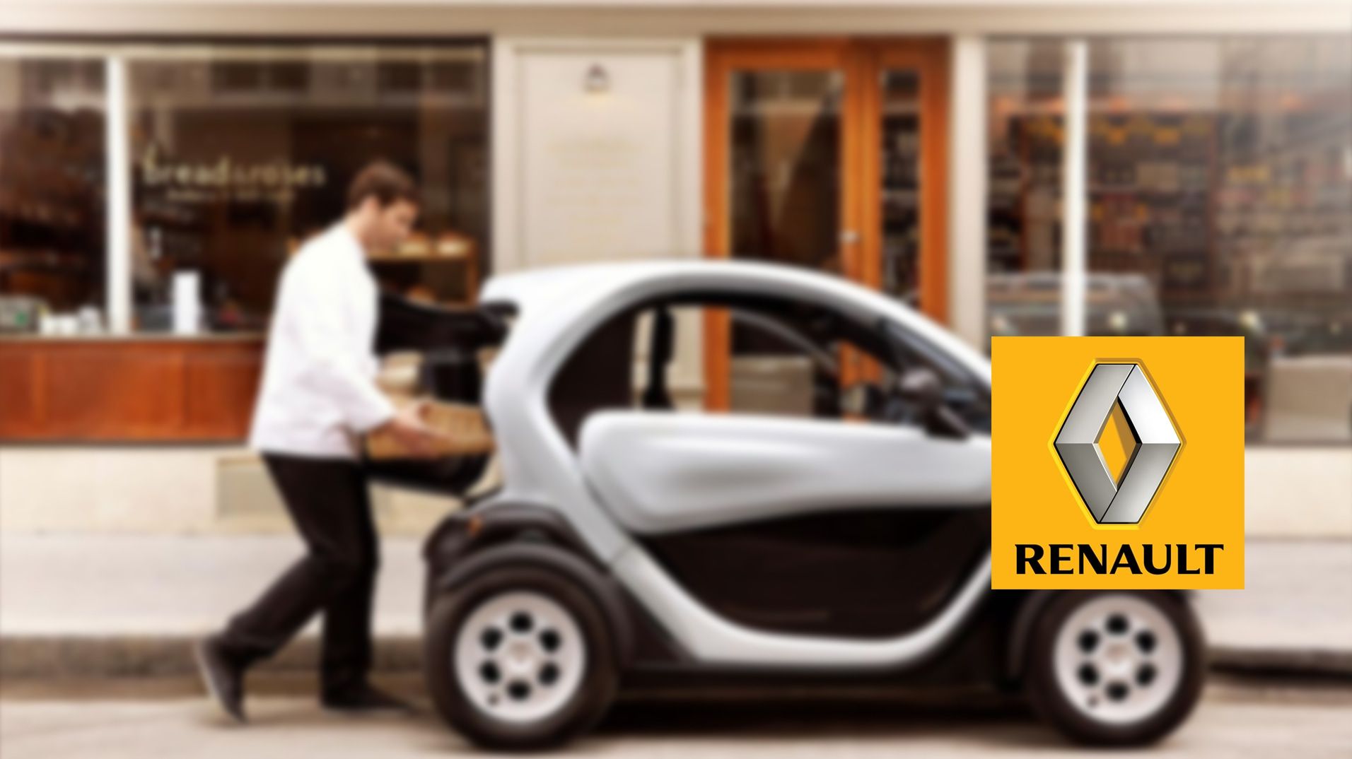 A Renault electric city car parked outside a café with the Renault TV identity overlaid.