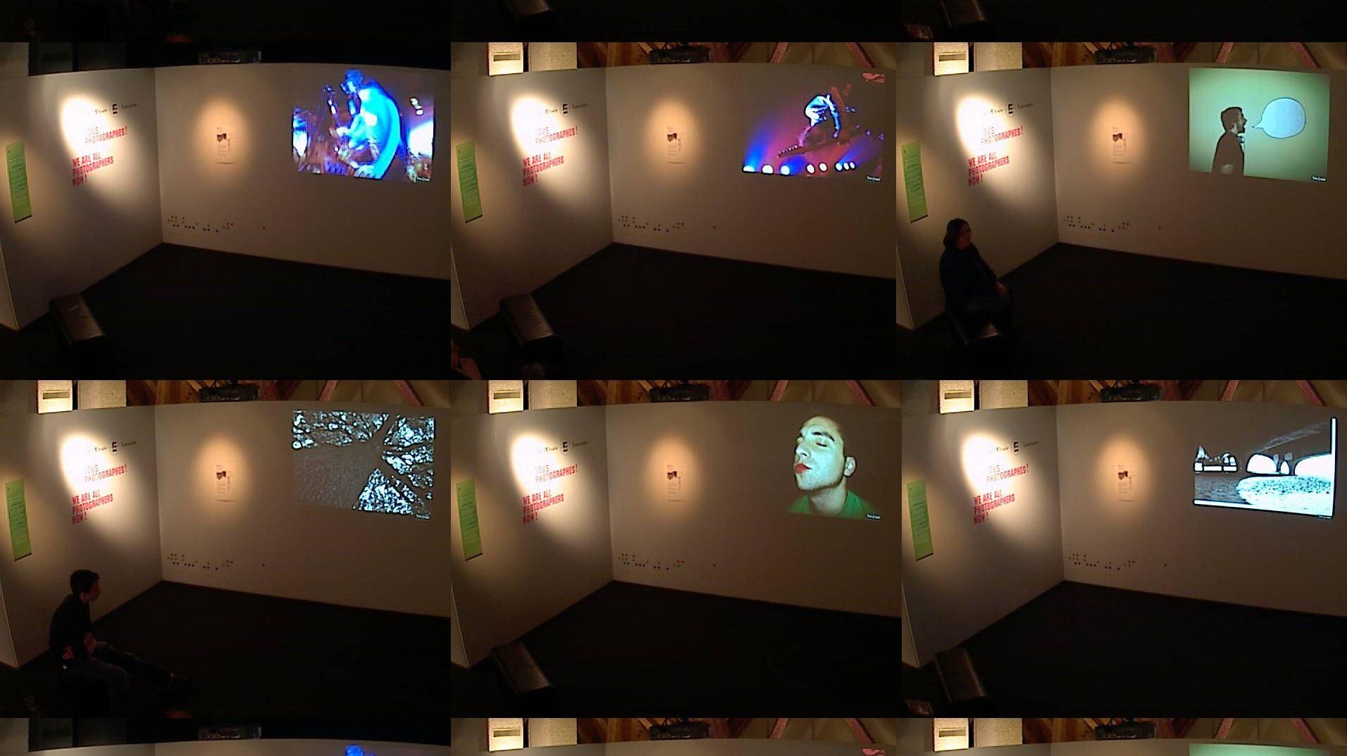 Exhibition visitors viewing projected photographic submissions in the gallery.