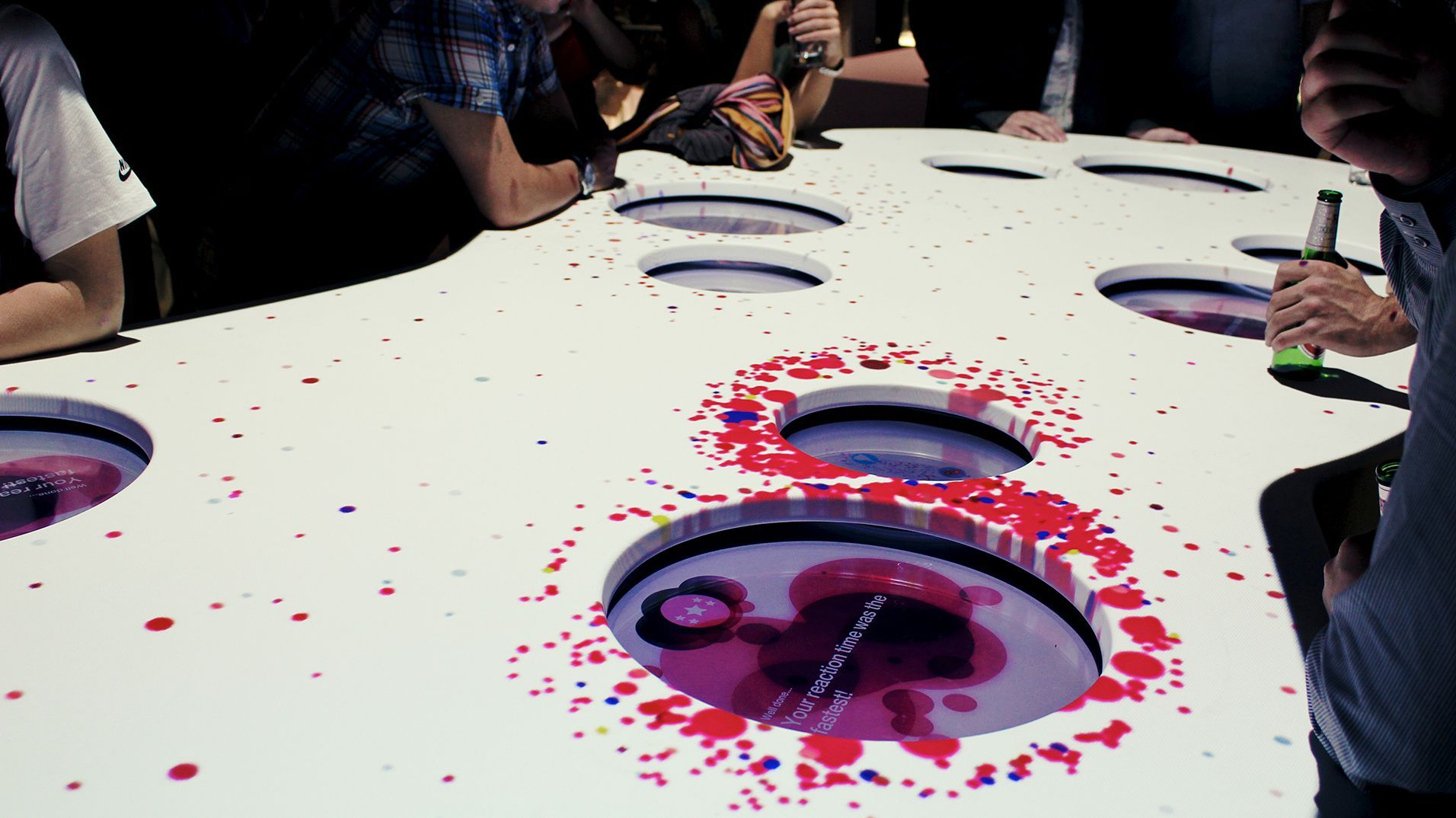 Several visitors answering questions together around the multiplayer table.